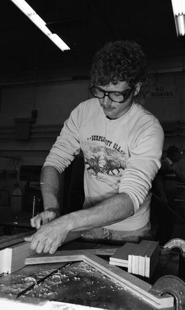 BCIT Carpentry, 1989, man wearing eye protection cutting wood [3 of 7 photographs]