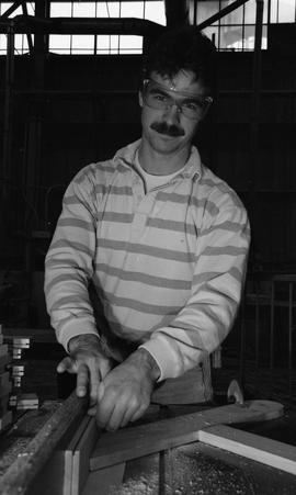 BCIT Carpentry, 1989, man wearing eye protection cutting wood [4 of 7 photographs]