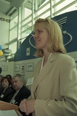 Open House 1998; woman stands behind podium on Open House BCIT stage