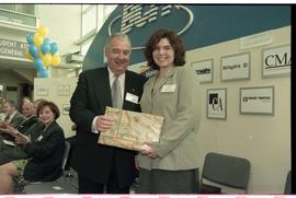Open House 1998; Judy and Peter Legge hold package with map wrapping in front of camera