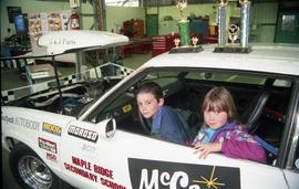 Open House 1998;  long view of two children sitting in driver's seat of McCain's racing car with ...