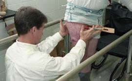 Man's residual limb being measured and examined [3 of 4 photographs]