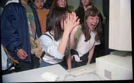 Open House 1998; two girls high fiving in front of computer [photograph 1 of 2]