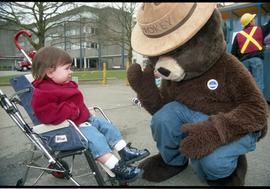 Open House 1998; upset child in stroller looking away from kneeling Smokey the bear [photograph 3...