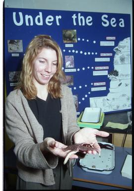 Open House 1998; woman holding starfish in front of under the sea display [photograph 2 of 4]