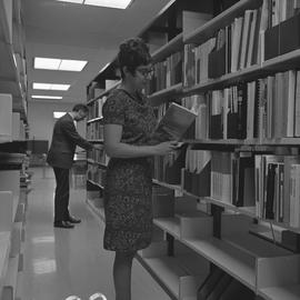 BCIT Burnaby campus library ; two people standing in an aisle looking at books