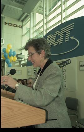 Open House 1998; older woman stands behind podium on Open House BCIT stage