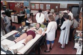 Open House 1986; various medical displays with volunteer displaying EEG [3 of 3 photographs]
