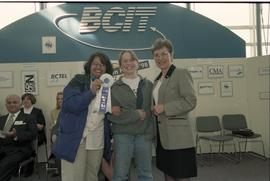 Open House 1998; two women pose with woman in suit while holding 1st place ribbon [photograph 2 o...