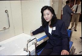 Open House 1992; woman in wheelchair turning bathtub faucet with safety bars [photograph 1 of 3]