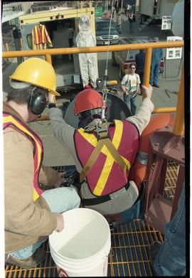 Open House 1998; woman in safety gear and line prepares to slide into confined space